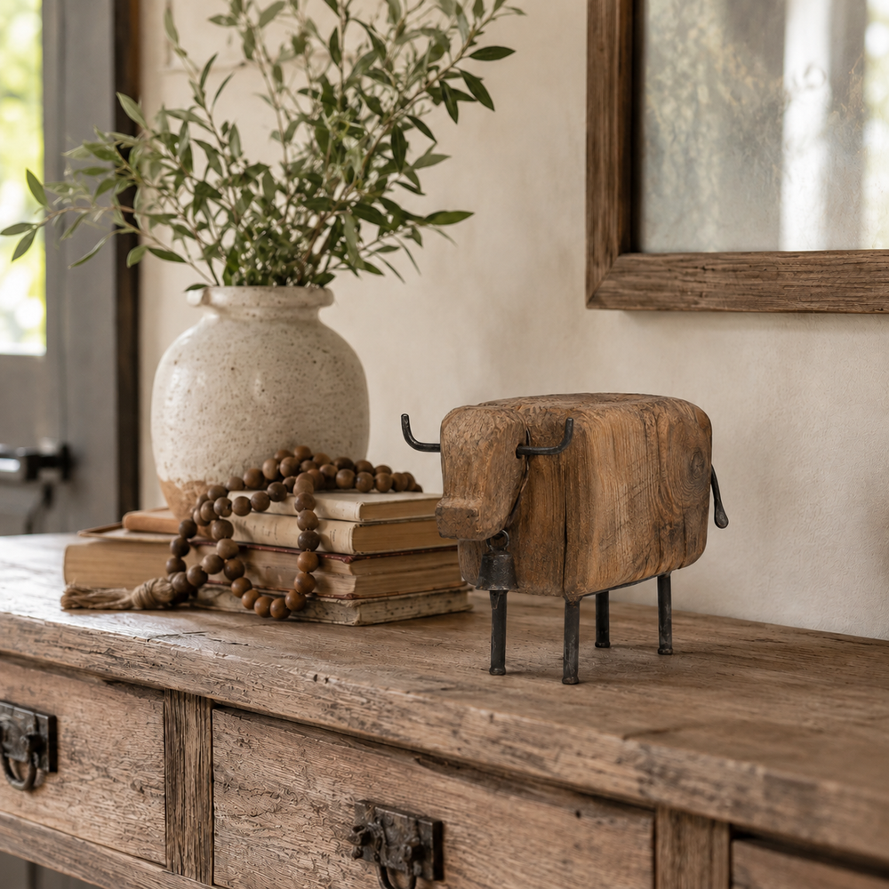 Vintage cow figurine styled on a wooden console