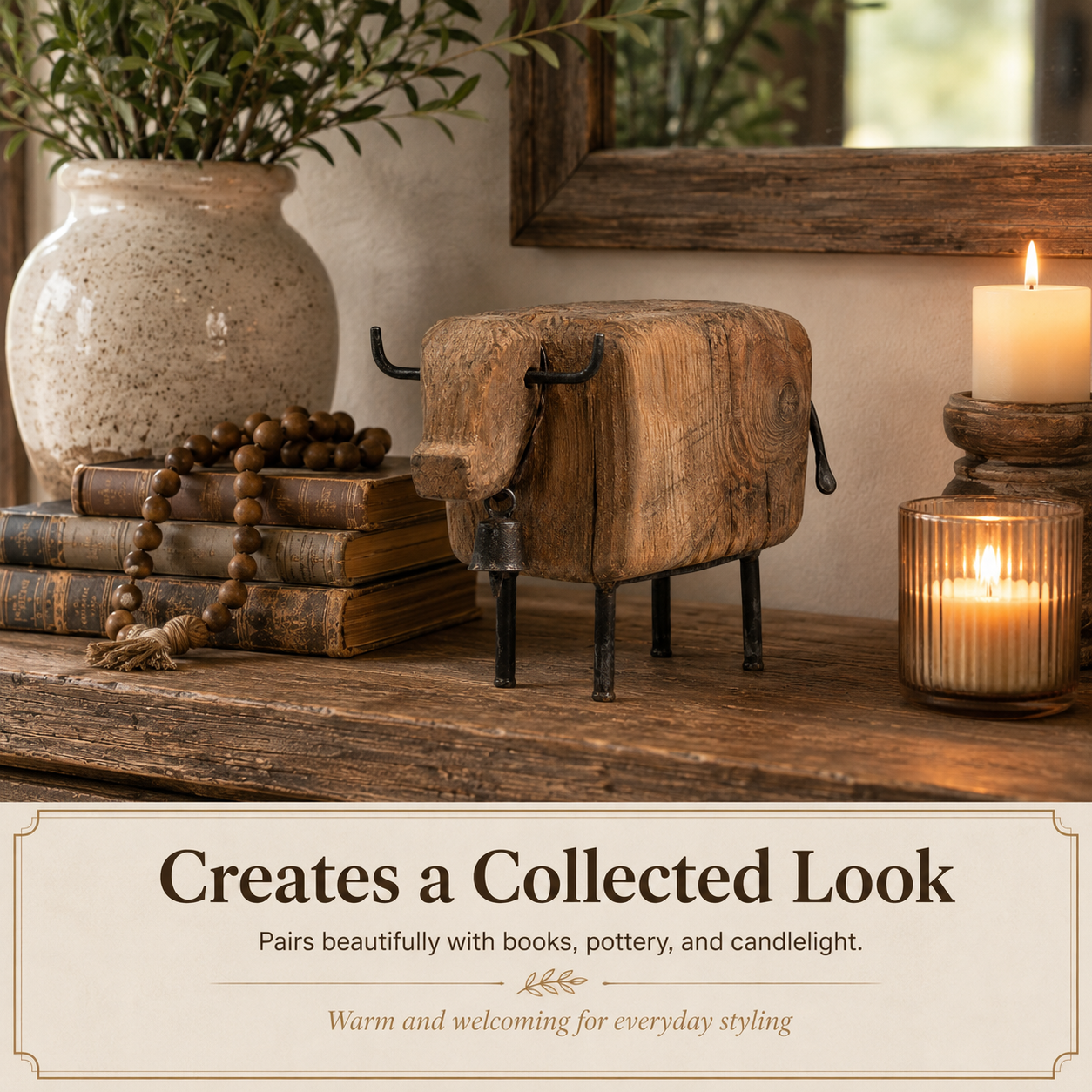 Vintage farmhouse cow figurine styled with books pottery and candlelight