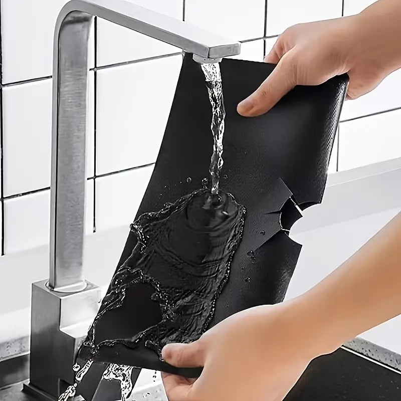 Washing reusable gas stove protector liner under running water